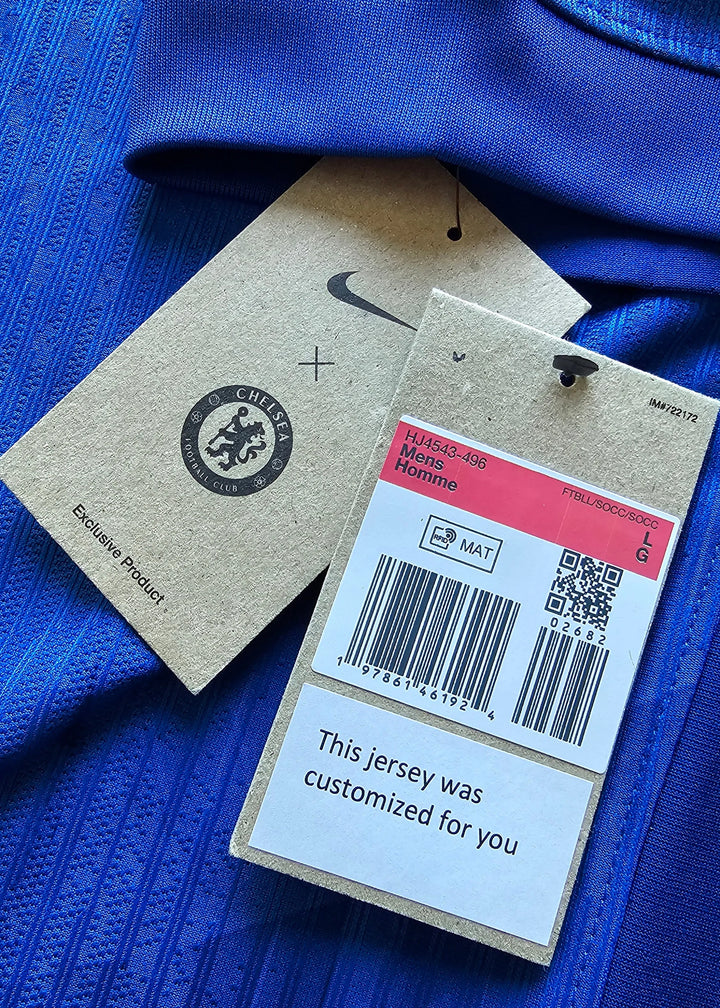 Close-up of Chelsea F.C. tags showing logo, size LG, and "This shirt was customized for you".