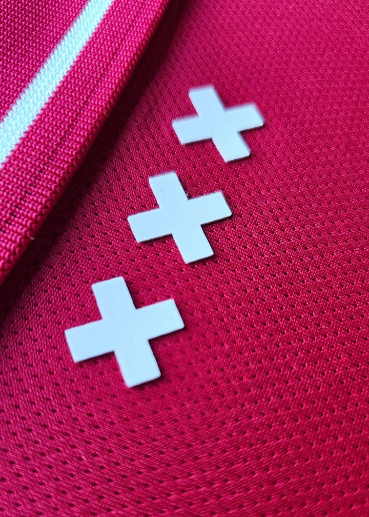 Back view featuring three white cross symbols on a red football shirt.
