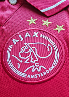 Crest detail with Ajax badge featuring three stars and AMSTERDAM in white embroidery.