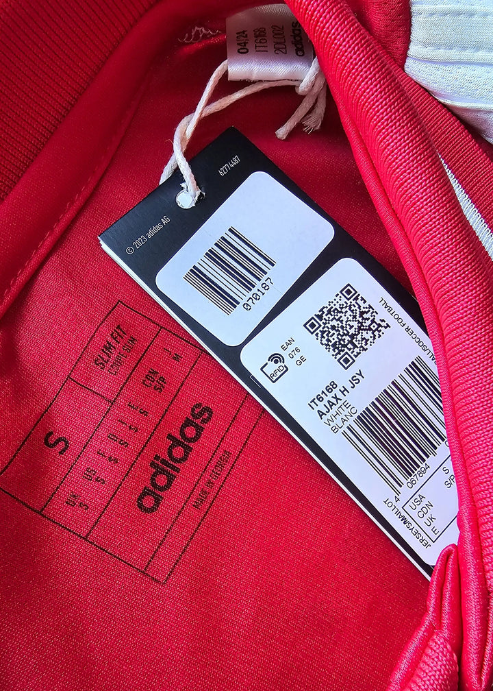 Size label showing 'S', adidas branding, and care instructions on a red football shirt.
