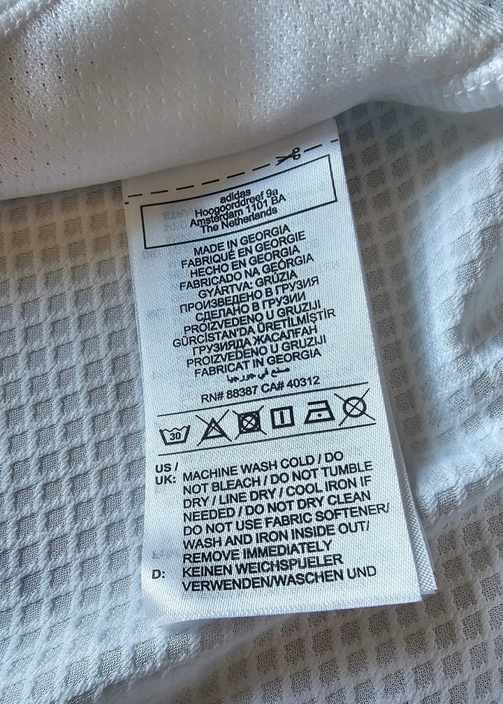 Care label with washing instructions, adidas branding, and made in Georgia details.