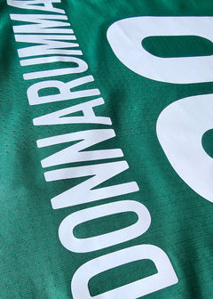 Close-up view of the No. 99 and name Donnarumma in white on a green football shirt.