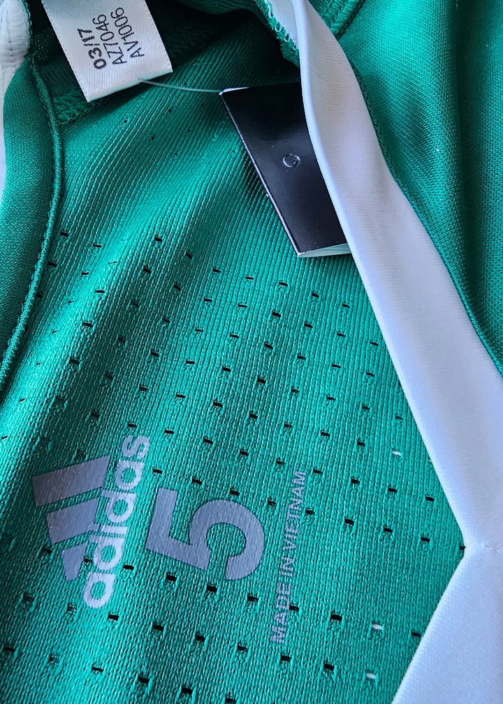 Close-up of the green fabric showing adidas logo, No. 5, and tag details.