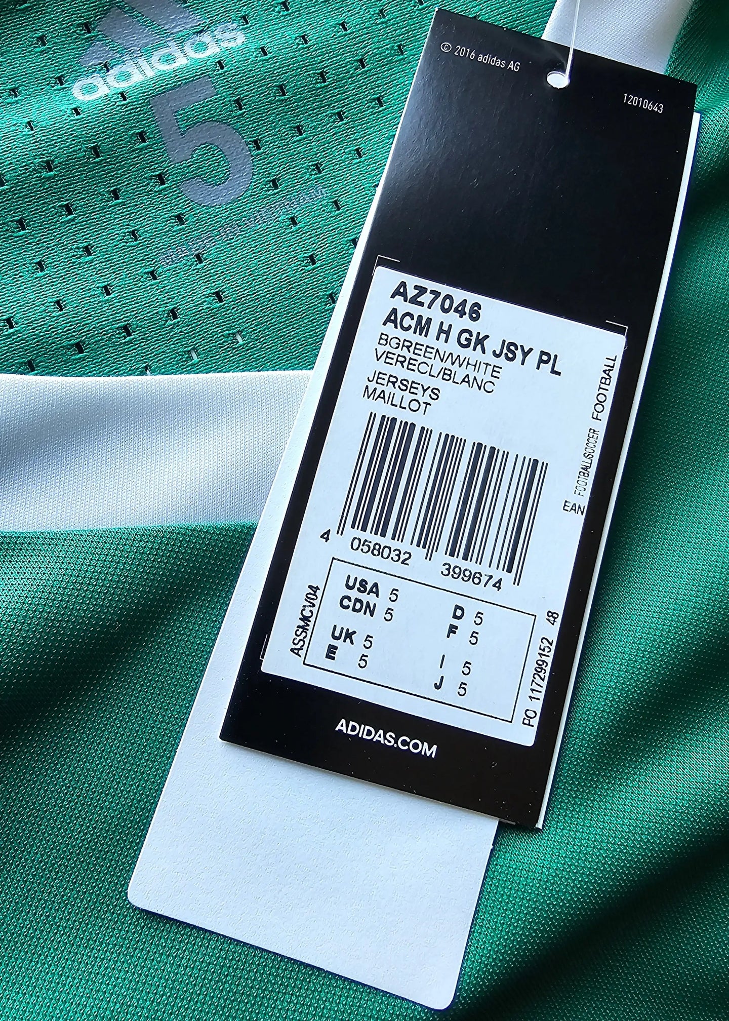 Close-up of the size tag showing size 5 and care instructions on a green soccer jersey with No. 5.