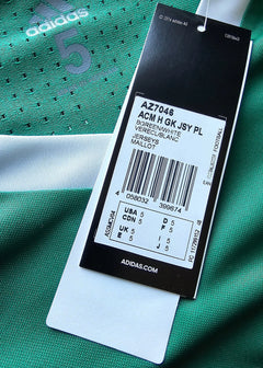 Close-up of the size tag showing size 5 and care instructions on a green soccer jersey with No. 5.