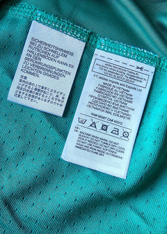 Care label displaying washing instructions and fabric details in multiple languages.