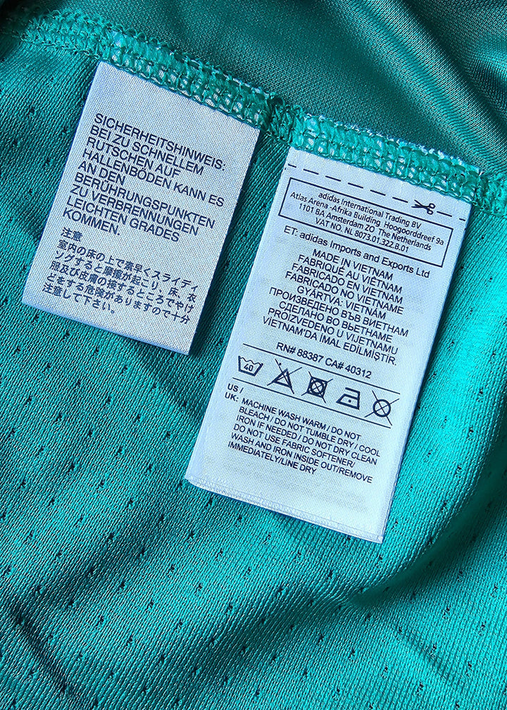 Care label displaying washing instructions and fabric details in multiple languages.