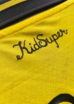 Detail showing the KidSuper logo in black on a yellow background.