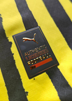 Close-up of the black licensed football patch with gold accents on yellow and black striped fabric.