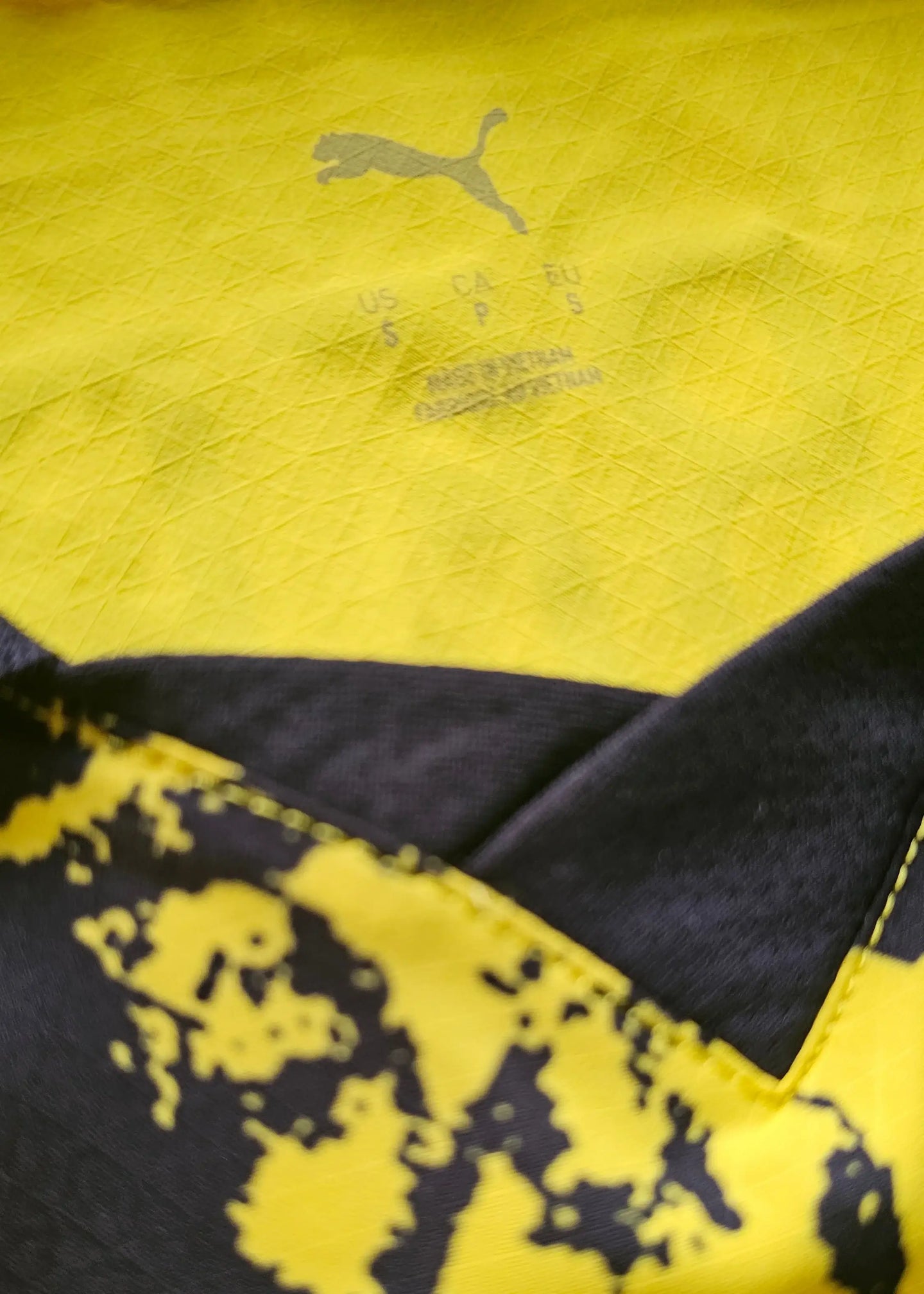 Detail view showing yellow and black fabric with PUMA logo and size information.