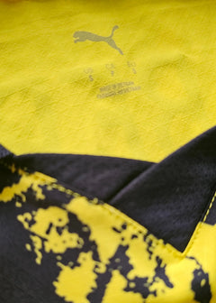 Detail view showing yellow and black fabric with PUMA logo and size information.