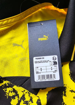 View showing yellow fabric with Puma logo and care tag details from the interior of the shirt.
