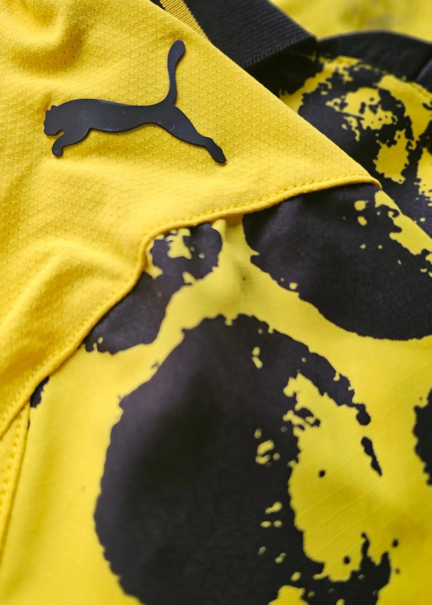 Close-up view showing the Puma logo on the signed Borussia Dortmund football shirt in yellow and black.
