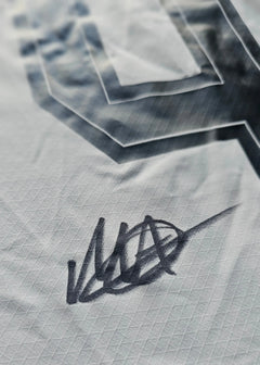 Close-up of Mathis Albert's signature on the Borussia Dortmund football shirt.