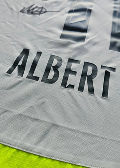 Detail view showing the name ALBERT and the number 1 on a grey football shirt.