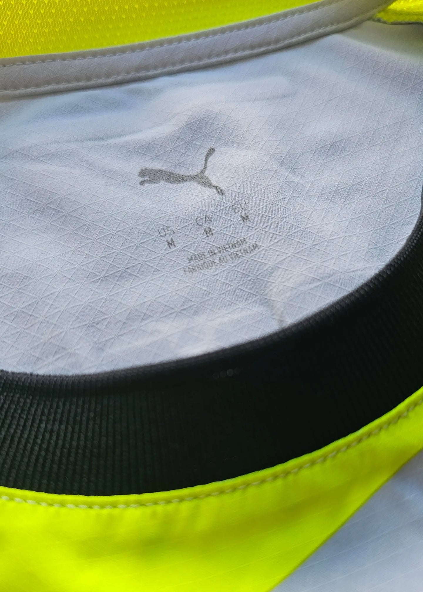 Detail view showing collar with Puma logo and care label for signed football shirt.