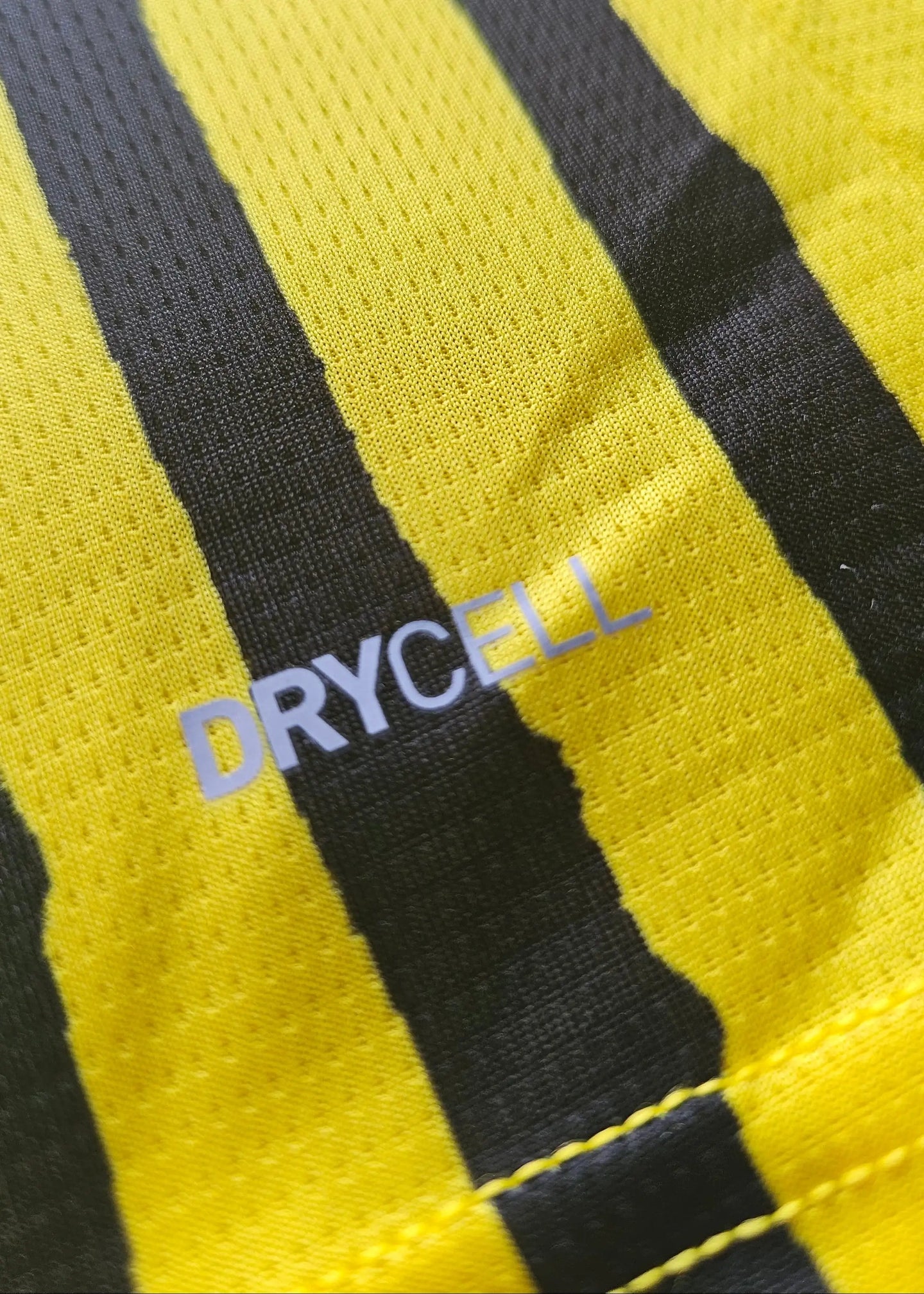 Close-up of yellow and black stripes with visible 'DRYCELL' text on fabric.