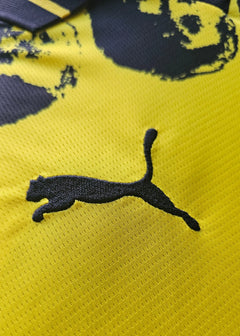 Detail showing the black Puma logo on a yellow background.