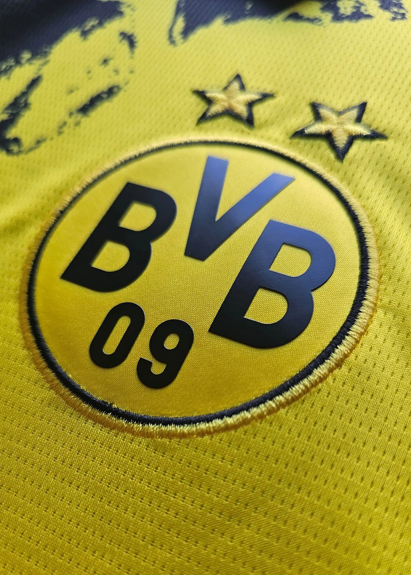 Close-up of Borussia Dortmund crest with two stars and 'BVB 09' text.