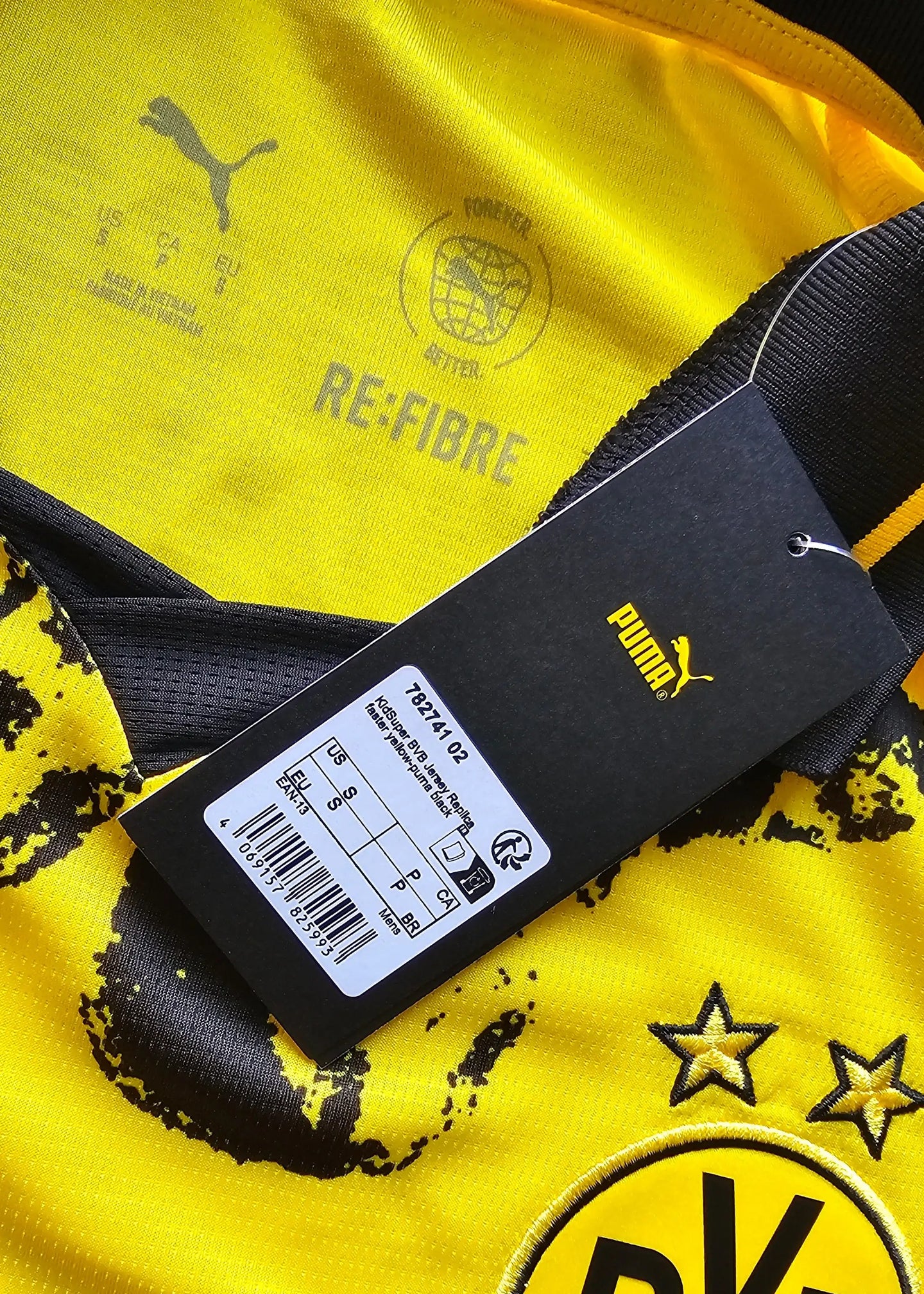 Crest detail showing Borussia Dortmund logo with two stars and Puma branding on yellow background.