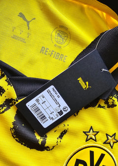 Crest detail showing Borussia Dortmund logo with two stars and Puma branding on yellow background.