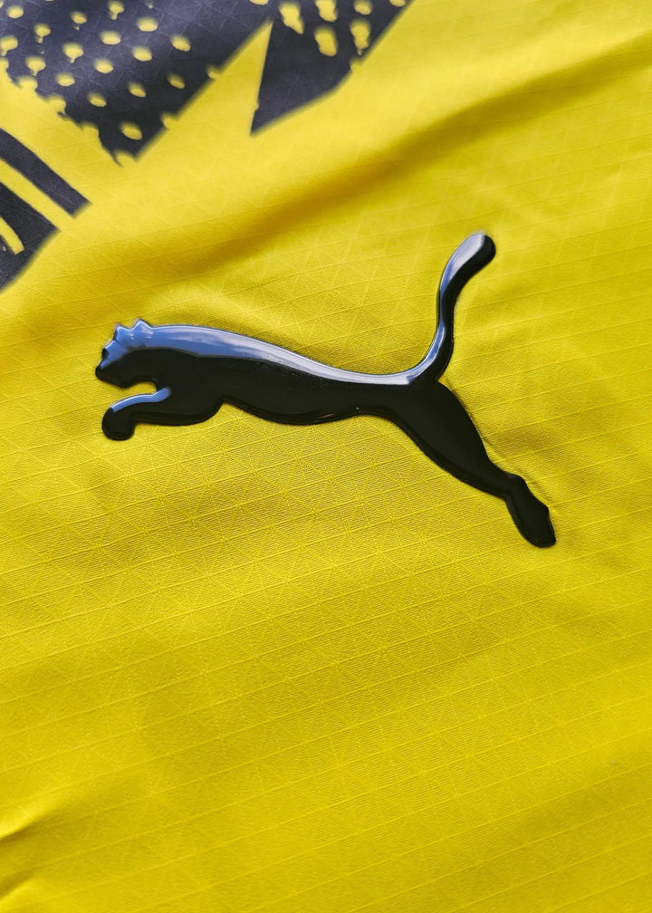 Close-up view of Puma wordmark on the yellow Borussia Dortmund football shirt.
