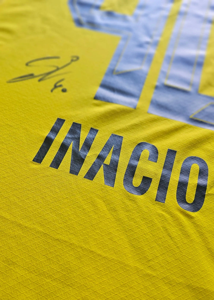 Detail of signed football shirt featuring INACIO and player signature in yellow and black.
