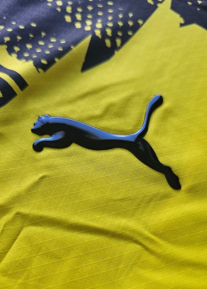Detail view featuring the black Puma logo on a yellow background.