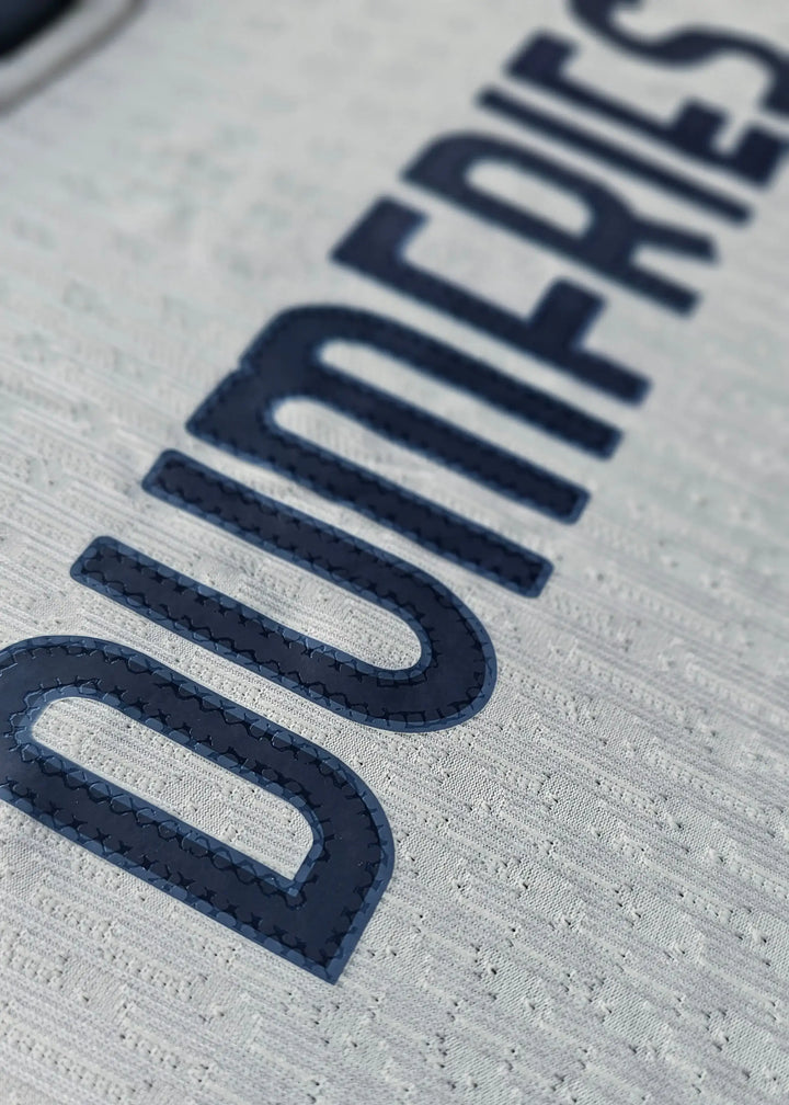 Close-up view showing the name DUMFRIES in navy lettering on a white Signed Denzel Dumfries football shirt.