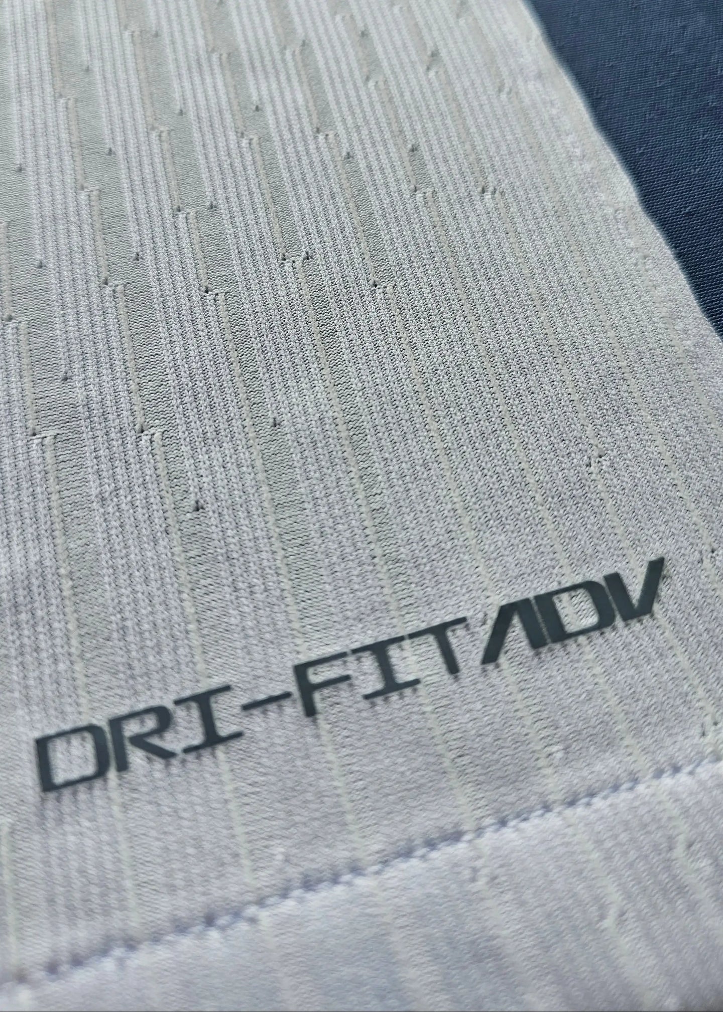 Close-up of fabric detail showing DRI-FIT/ADV technology on the signed Internazionale football shirt.