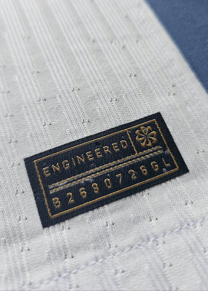 Close-up of label showing 'ENGINEERED' and code '826907269GL' on the football shirt.