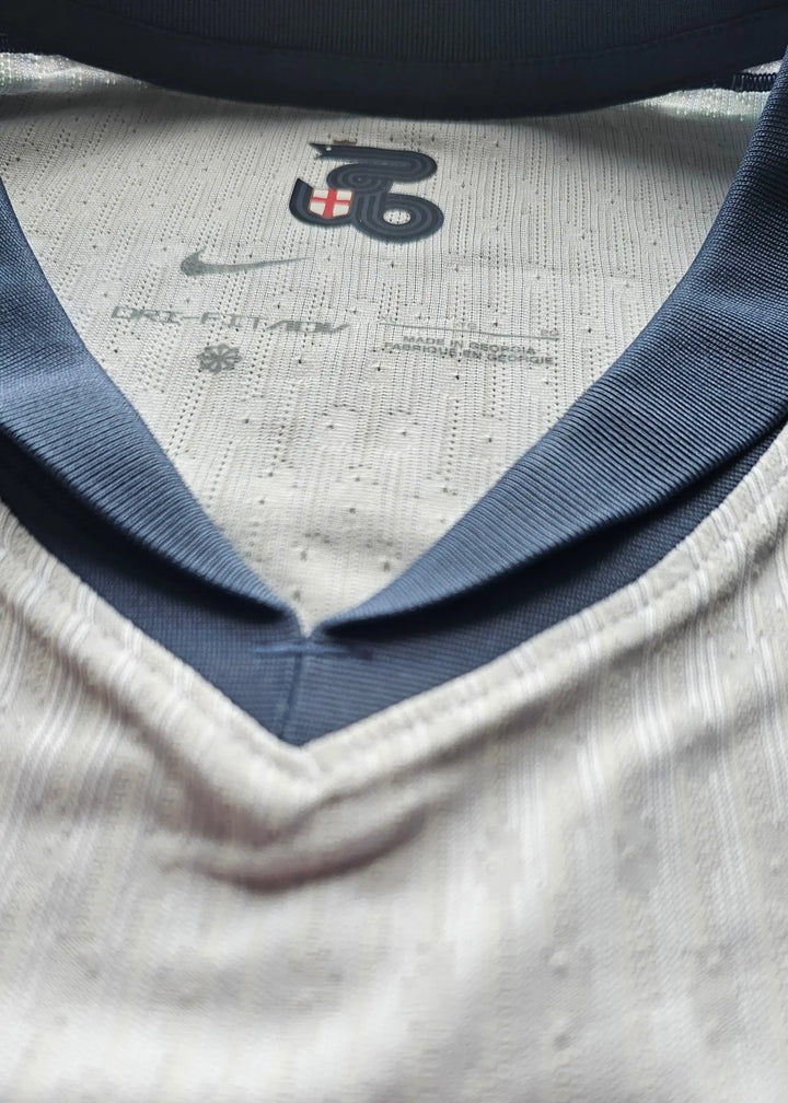 Close-up of collar featuring Nike logo and size label with white and navy colors.