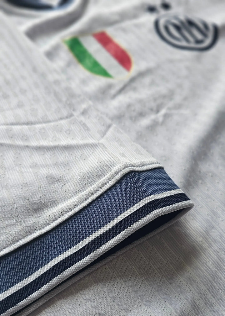 Close-up of the Inter Milan crest and navy stripes on the sleeve of a signed football shirt.