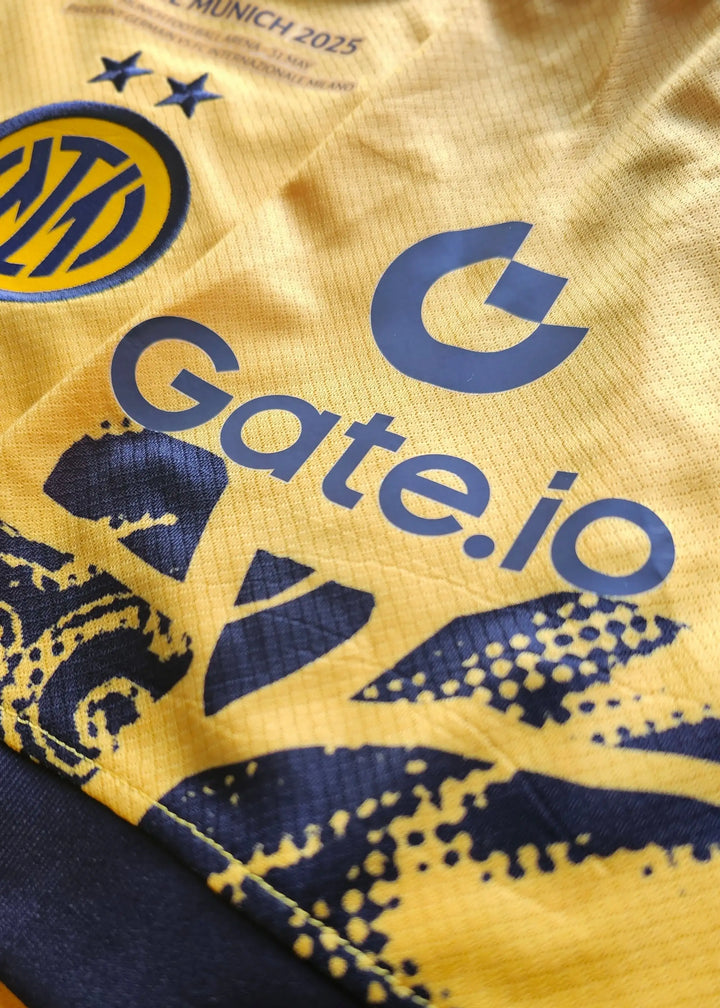Close-up of yellow shirt featuring Inter Milan crest, two stars, and Gate.io sponsor logo.
