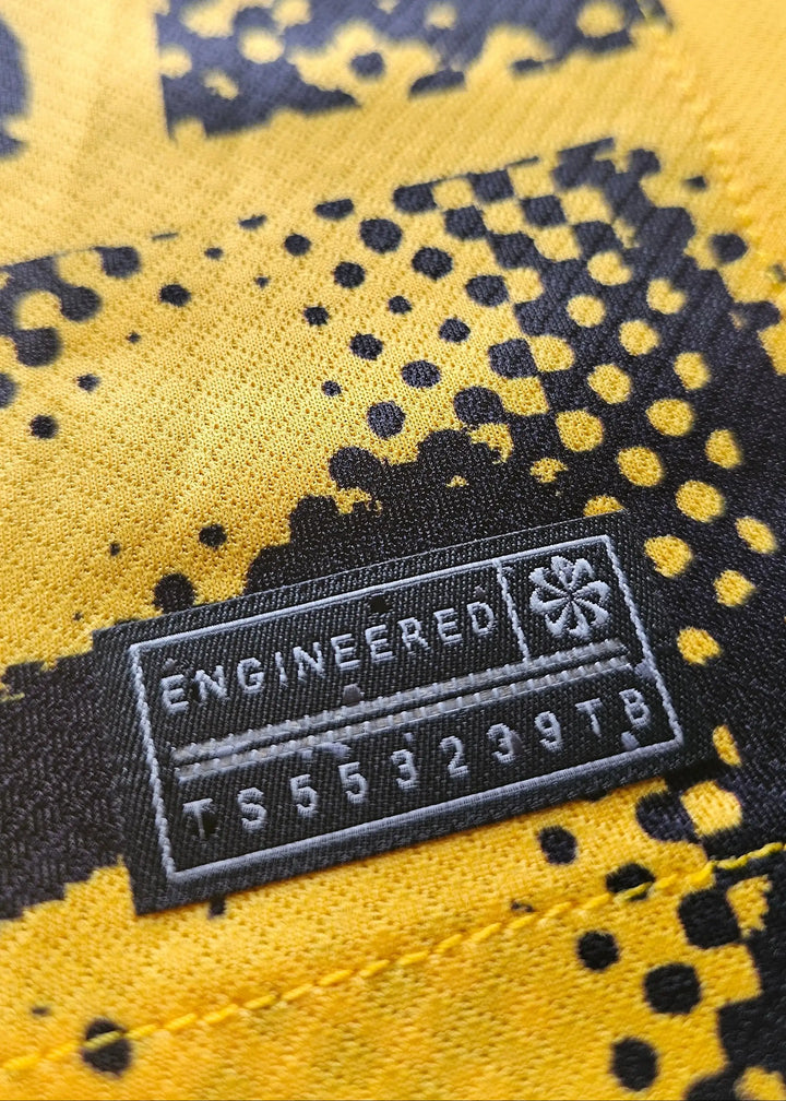 Close-up of engineered tag showing 'ENGINEERED' and code 'TS553239TB' on yellow and black fabric.