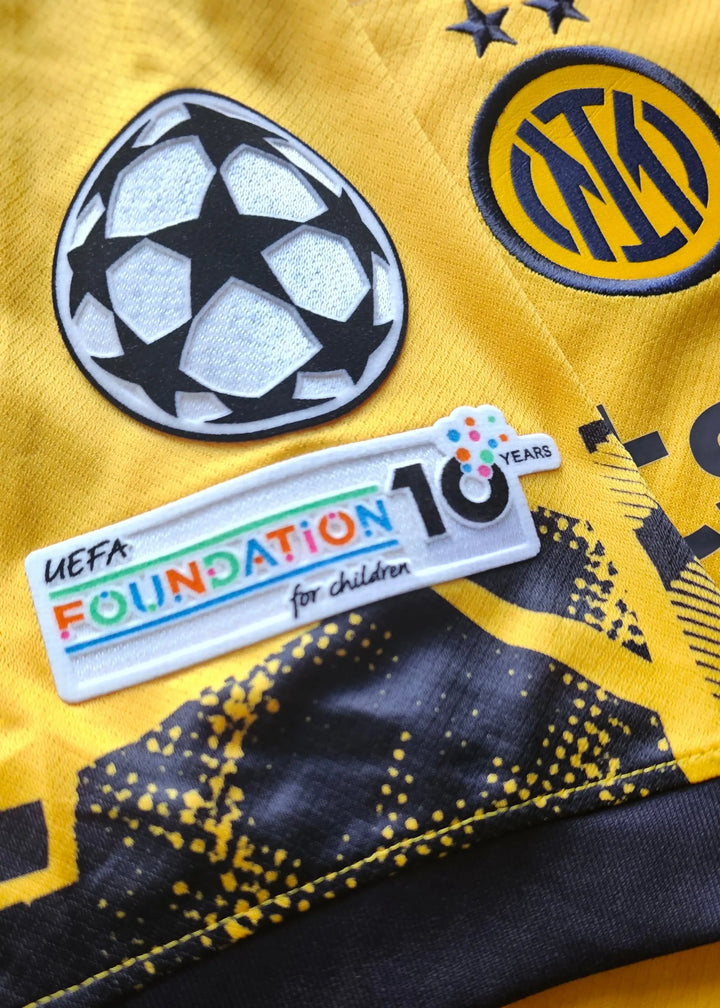 Close-up of crest showing Inter Milan logo, UEFA Champions League badge, and Foundation 10 Years patch.