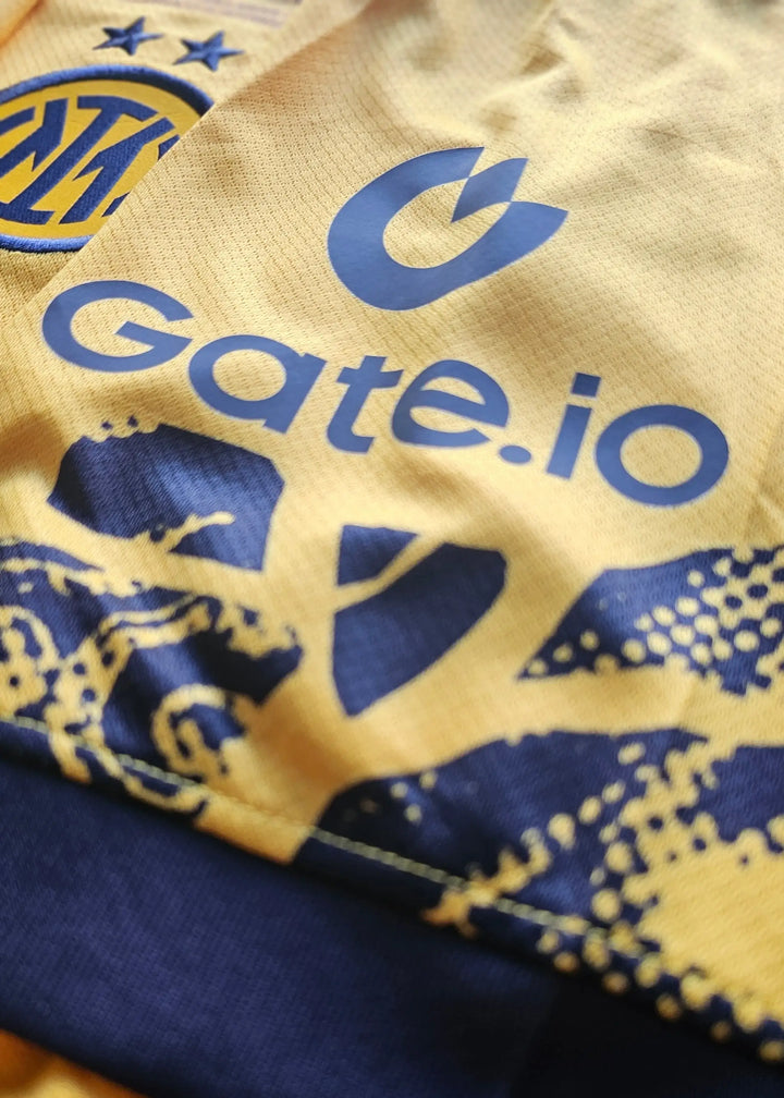 Close-up showing the Inter Milan crest and Gate.io logo on a yellow football shirt.