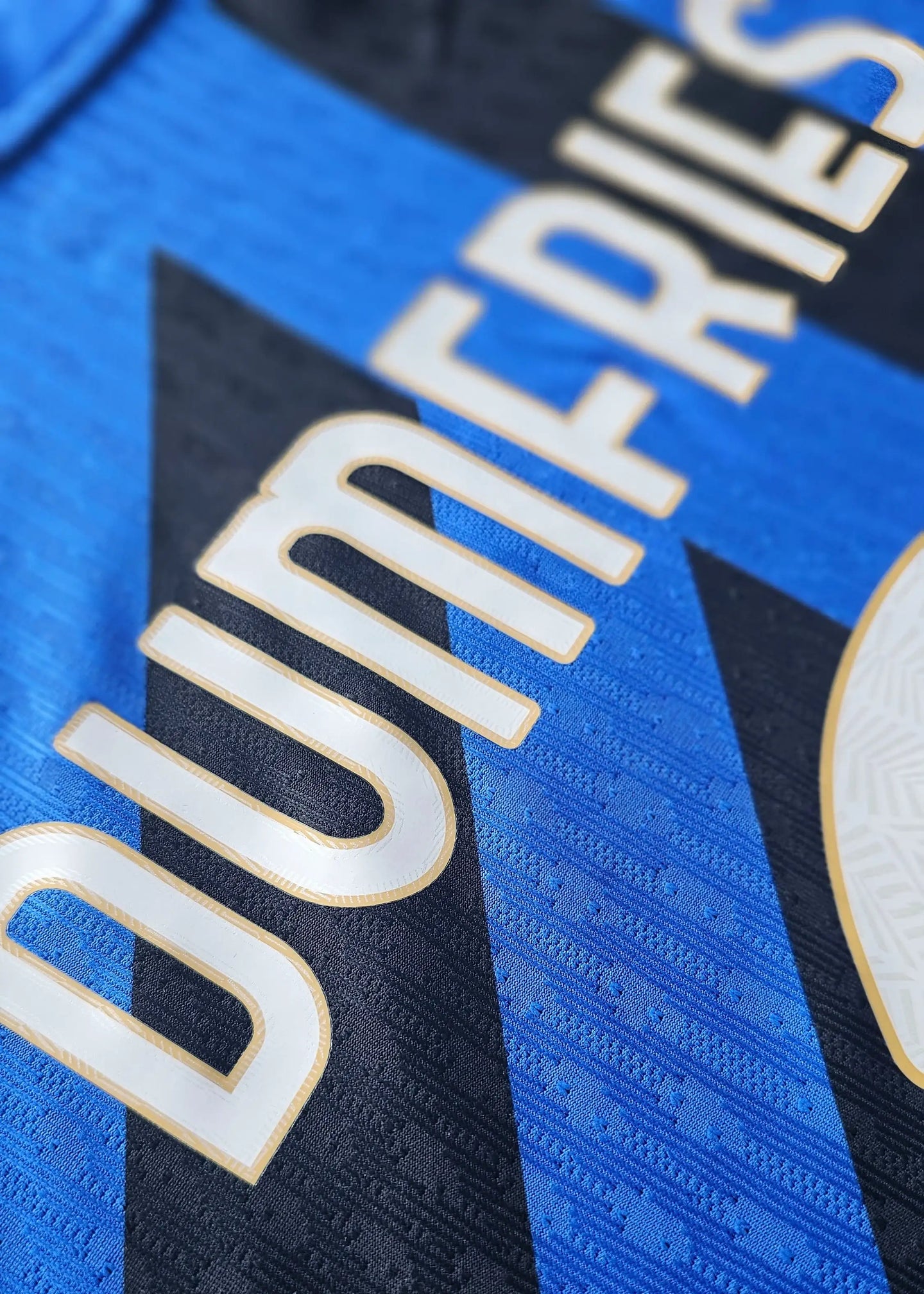 Close-up detail showing the name Dumfries on the signed football shirt in black and blue.