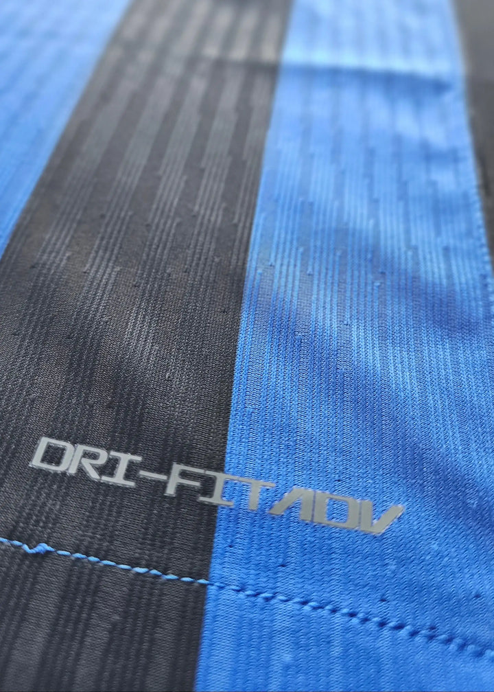 Close-up detail showing DRI-FIT ADV label on the signed Denzel Dumfries Inter Milan football shirt.