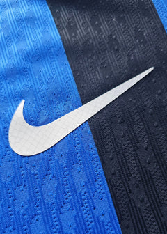 Close-up detail of the Nike logo on the blue and black stripes of the Inter Milan football shirt.