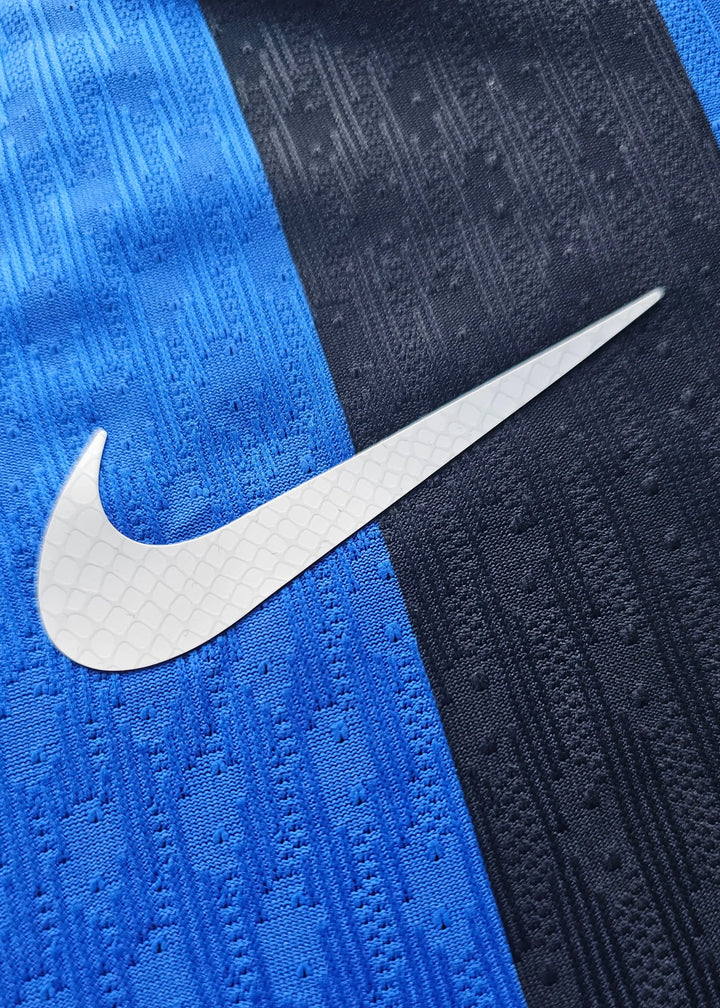 Close-up detail of the Nike logo on the blue and black stripes of the Inter Milan football shirt.