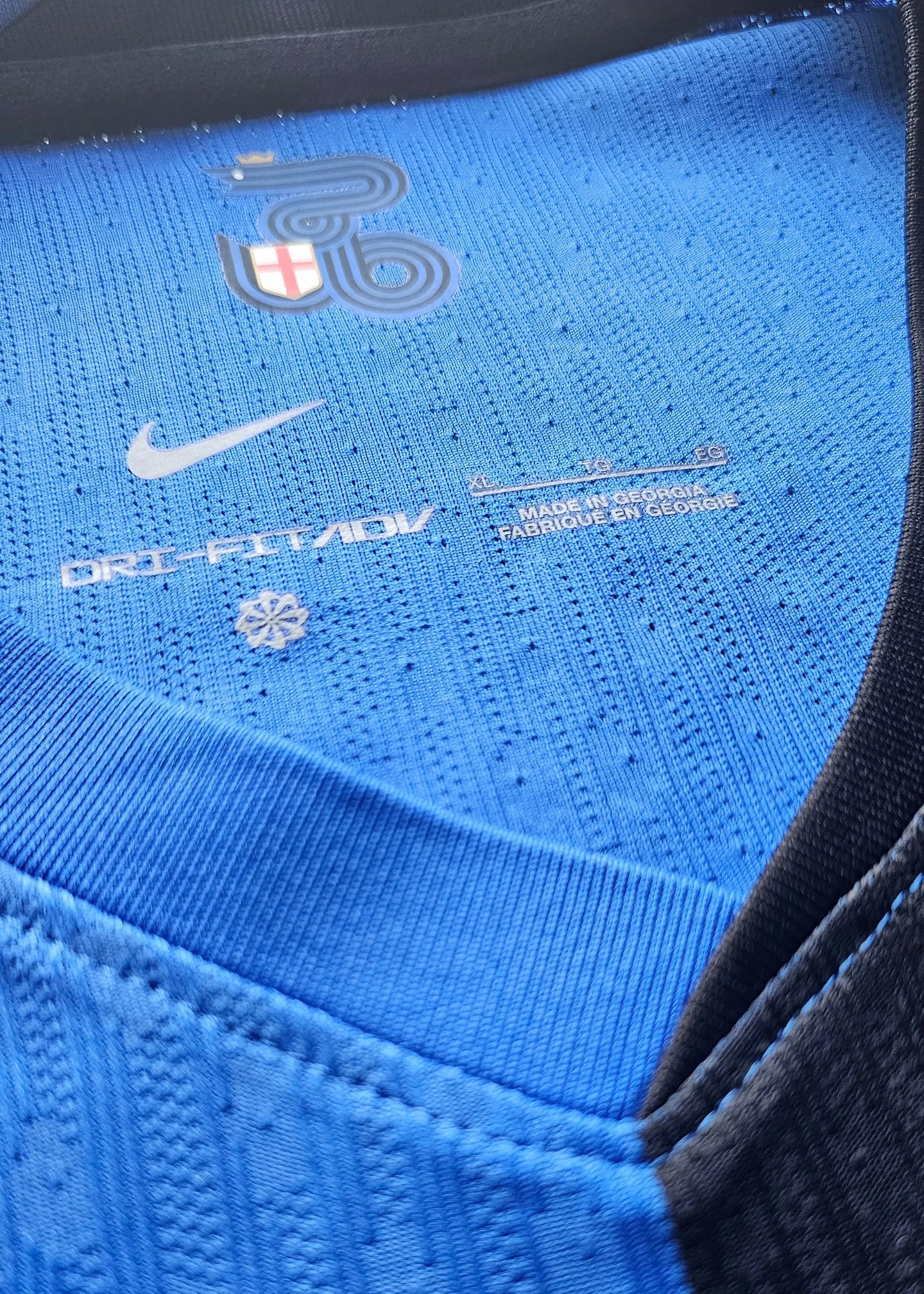 Neck area showing Nike logo, Dri-FIT tag, and size label (XL) on blue fabric.