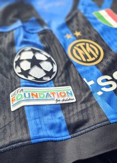 Close-up view showing the UEFA Foundation for Children patch and Inter Milan crest with two stars.
