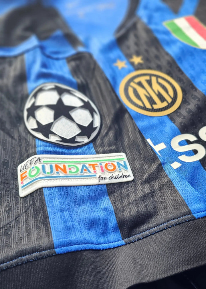 Close-up view showing the UEFA Foundation for Children patch and Inter Milan crest with two stars.