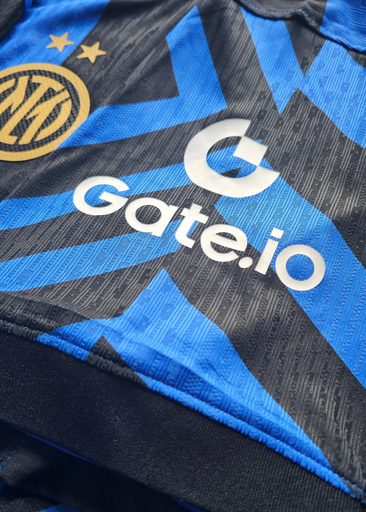 Close-up of Inter Milan crest with two stars and Gate.io sponsor logo on blue and black football shirt.