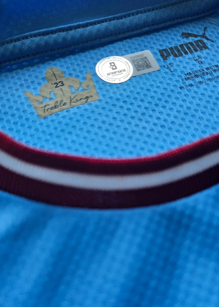 Close-up of the collar interior showing the gold 'Treble Kings' badge and PUMA logo, with a Beckett sticker.