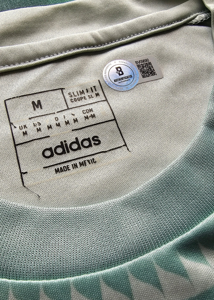 Close-up of Adidas label on a garment with a blue tag.