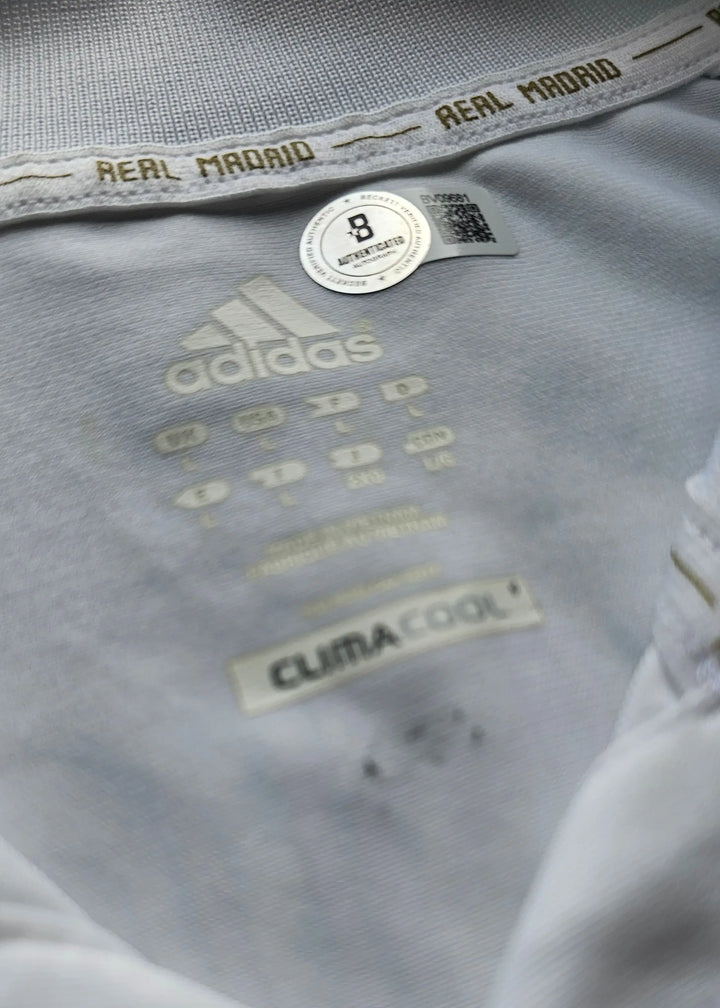 Close-up of a sports shirt with Adidas and Real Madrid branding.