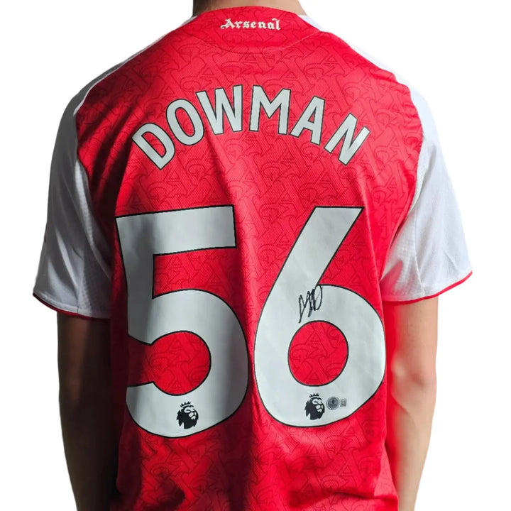 Back view featuring Dowman, No. 56, and a visible signature on a red Arsenal football shirt.