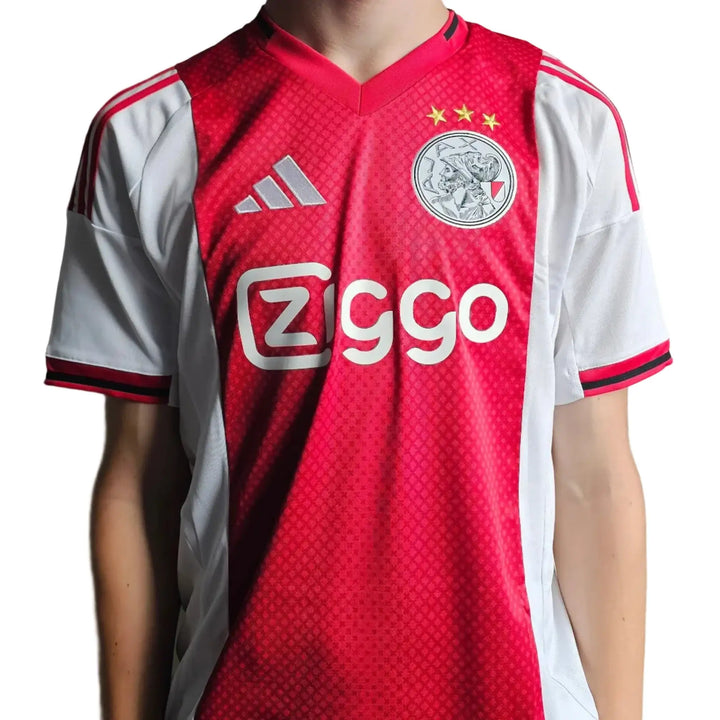 Front view of signed football shirt featuring red and white colors, Ziggo logo, and Ajax crest with three stars.
